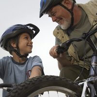 Grandson and grandfather stay healthy by riding bicycles and eating healthy food